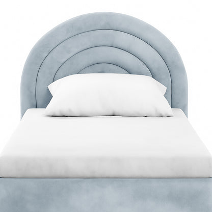 Estilla Velvet Rainbow Bed in Ice Blue features a scalloped, rainbow-arc headboard in soft blue velvet, with a simple white mattress cover and pillow, embodying charm and practicality for cosy sleep.