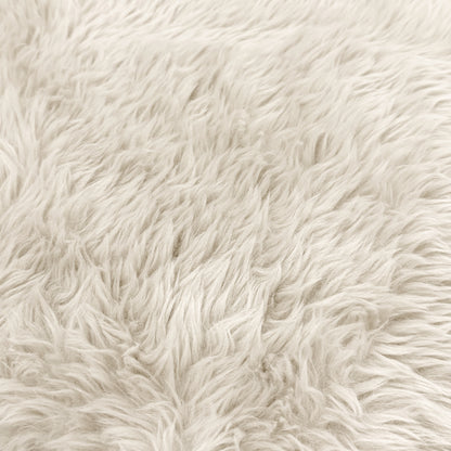 Close-up of cream faux fur upholstery texture.