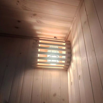 Luxo Kiima 6 Person Hybrid Finnish Outdoor Sauna in Natural features a rustic wood-panelled corner with a cage-style light fixture and slatted wooden shade, enhancing its authentic, cozy ambiance.