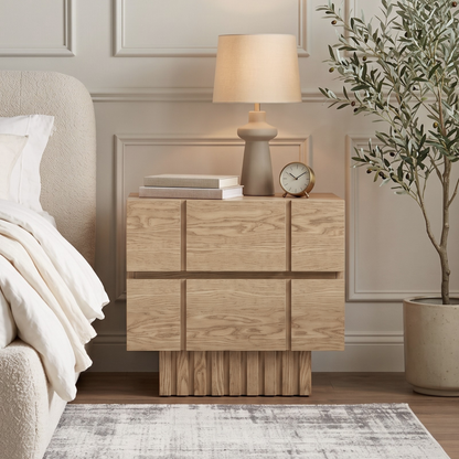 Wooden nightstand styled next to a bed in a bedroom