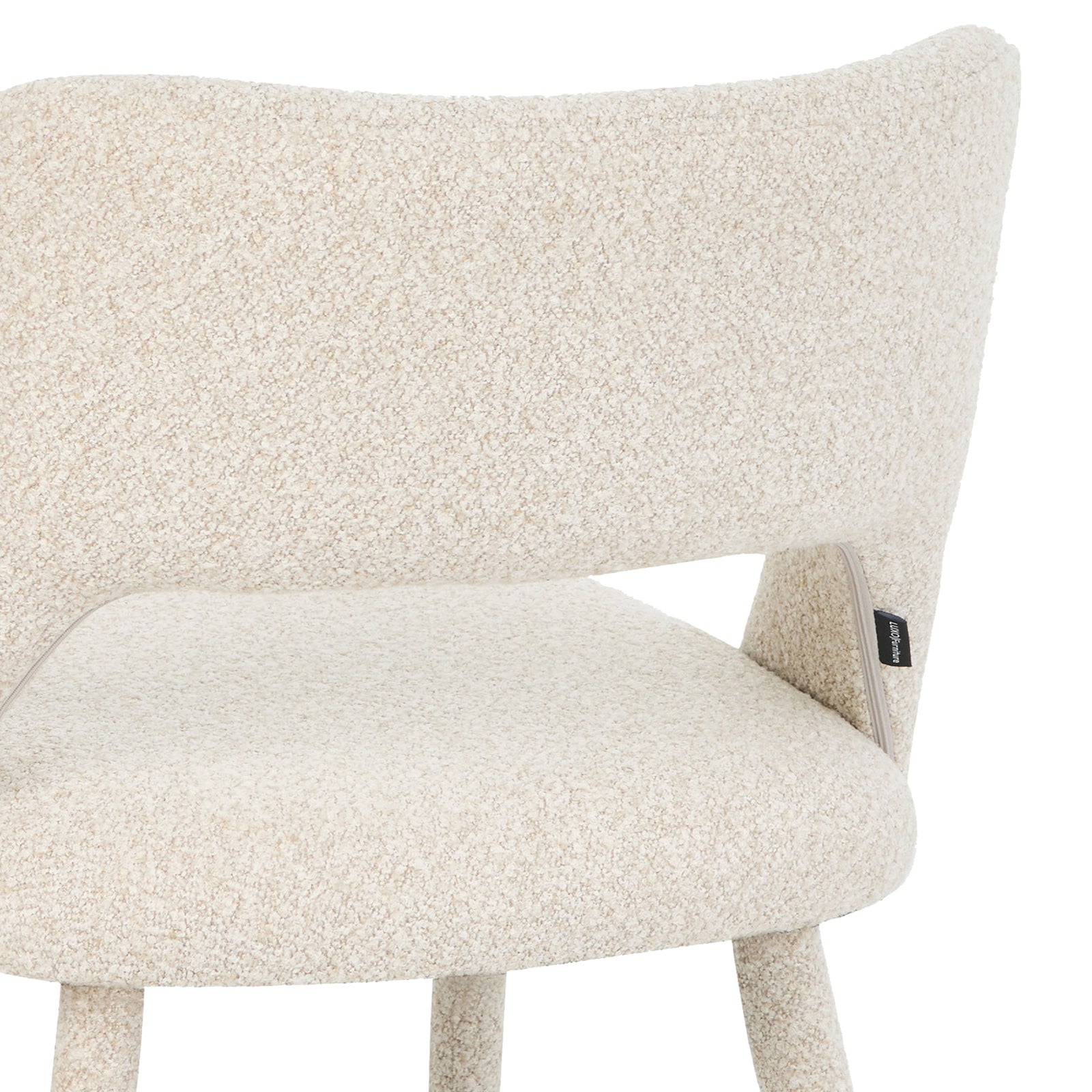 Partial side view of chair backrest and seat with fabric label on white background