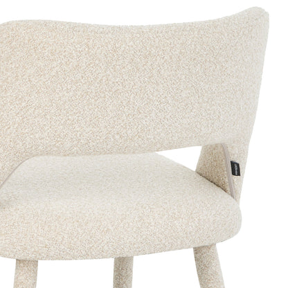 Partial side view of chair backrest and seat with fabric label on white background