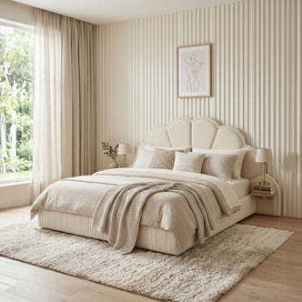 Cream upholstered bed in styled bedroom with bedding and decor