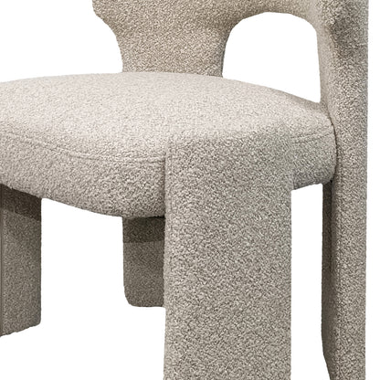 Lunari Bouclé Curved Accent Chair in Beige features a close-up of its cream-colored bouclé fabric, rounded seat, connected backrest, and chunky, slightly flared legs, offering compact comfort and style.