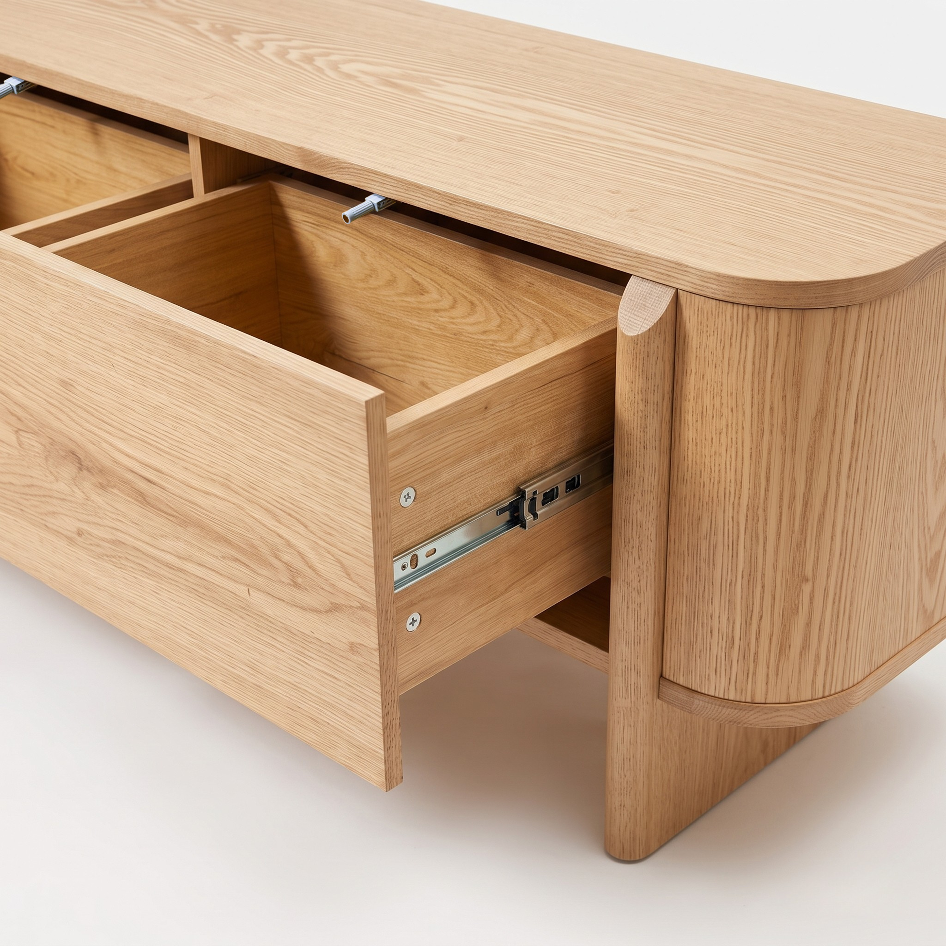 Close view of a light wood furniture piece with one open drawer on a white background