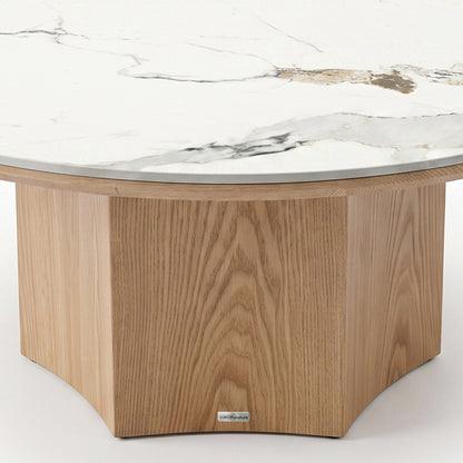Close-up of the lower portion of a round coffee table with wood base and white tabletop