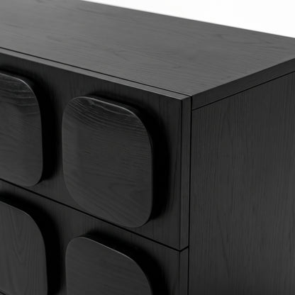 Close-up of a black wooden dresser corner with geometric drawer fronts
