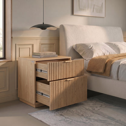 Wooden nightstand with open drawers beside a bed in a styled bedroom