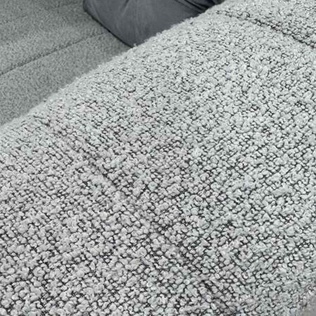 Close-up of the Parisa 4 Seater Tufted Boucle Sofa with Chaise in Light Grey, showcasing its soft, loop-pile bouclé fabric texture, highlighting the plush, nubbly surface characteristic of the upholstery.