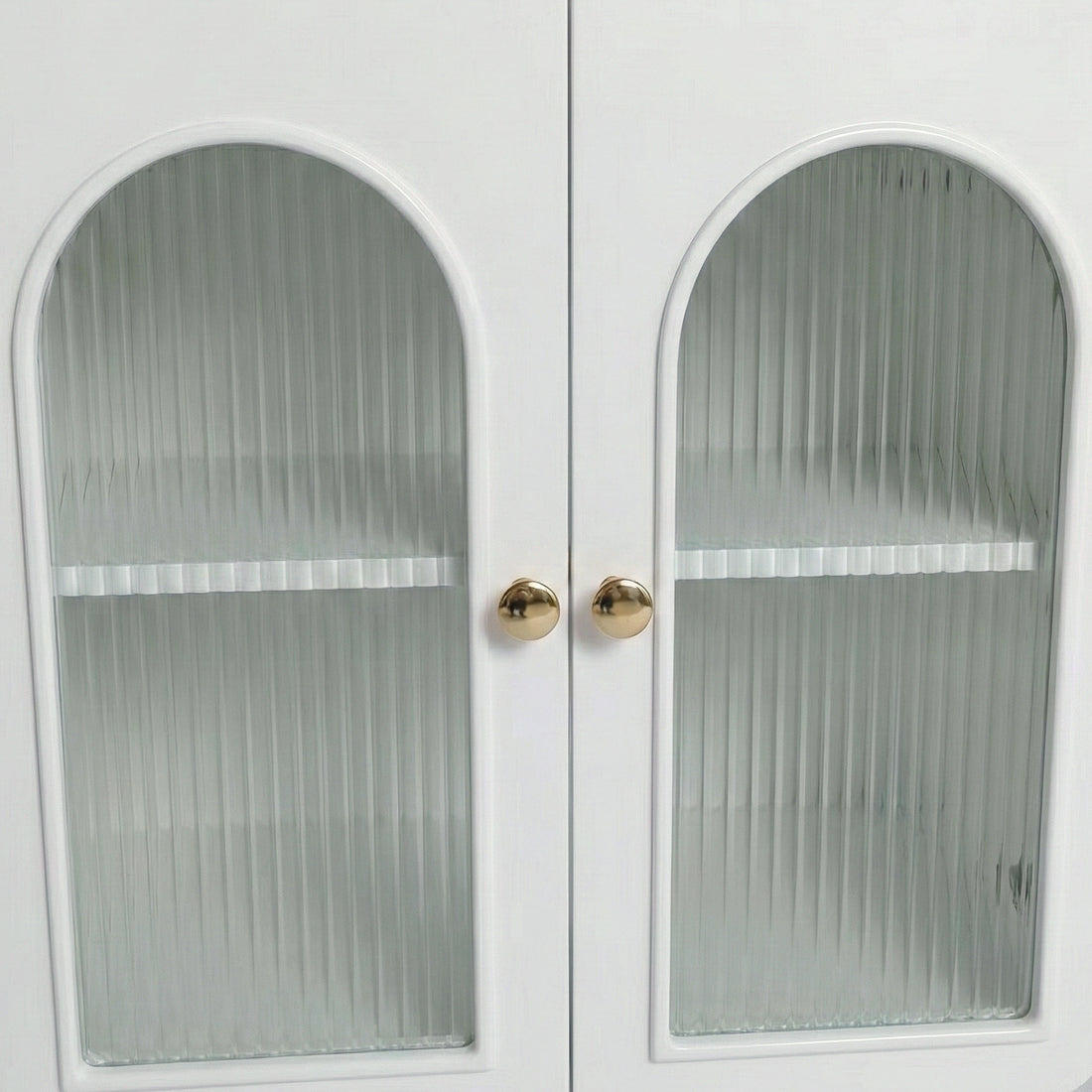 Close-up of white cabinet doors with arched ribbed glass panels