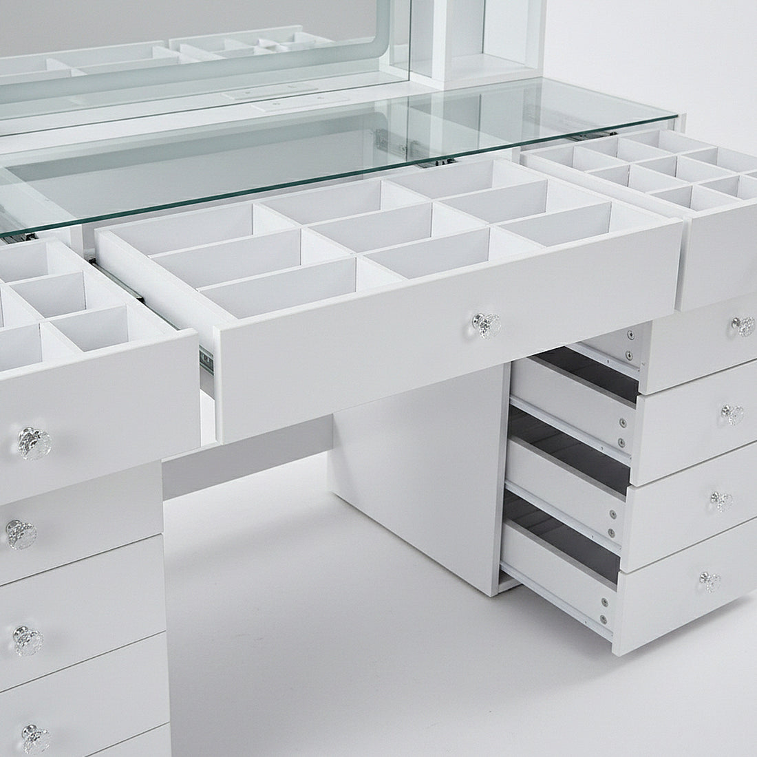 Detail view of vanity table storage compartments and open drawer sections on white background