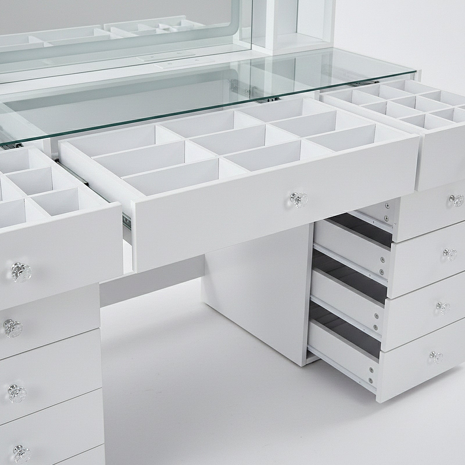 Detail view of vanity table storage compartments and open drawer sections on white background