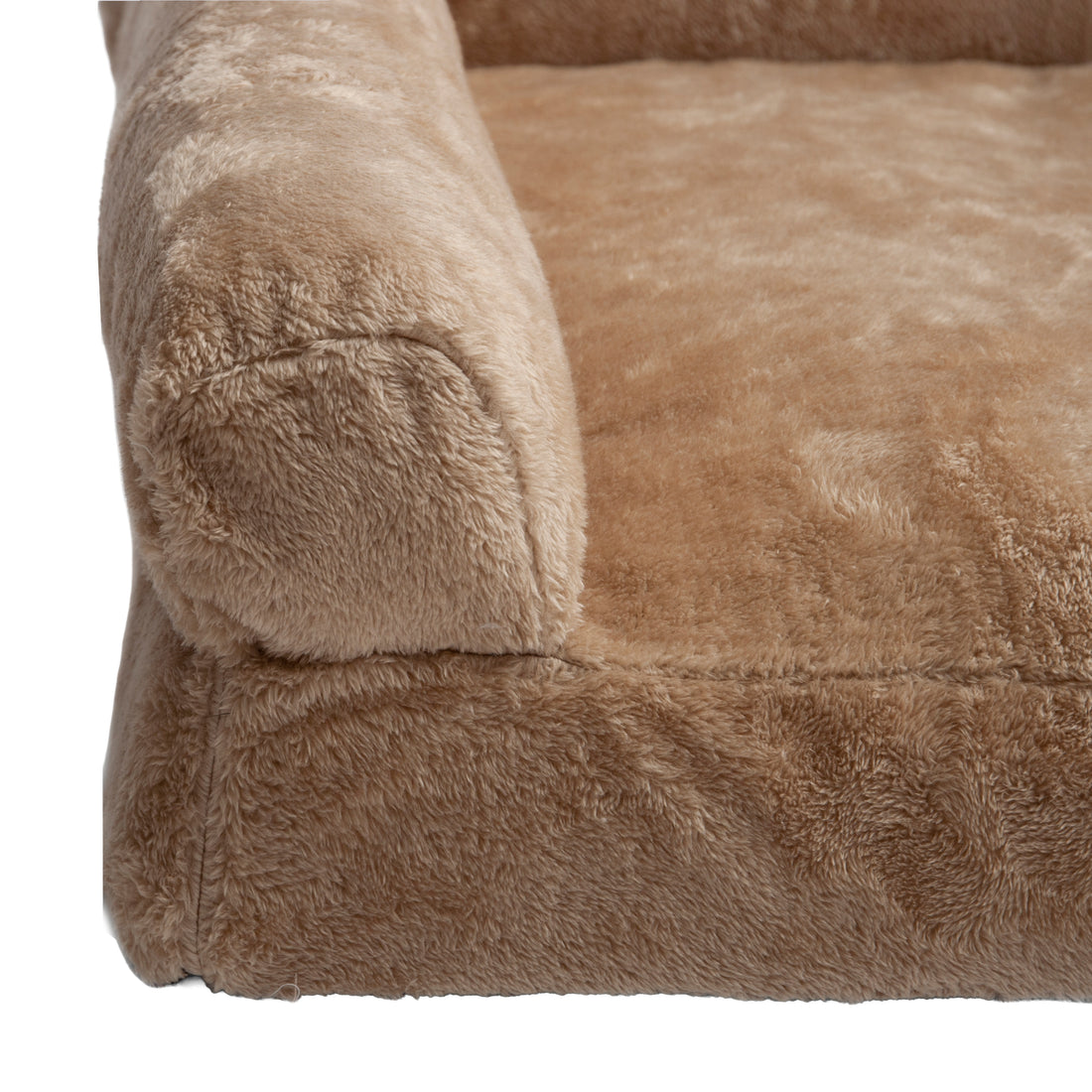 Partial view of tan plush fabric and bolster of pet bed on white background
