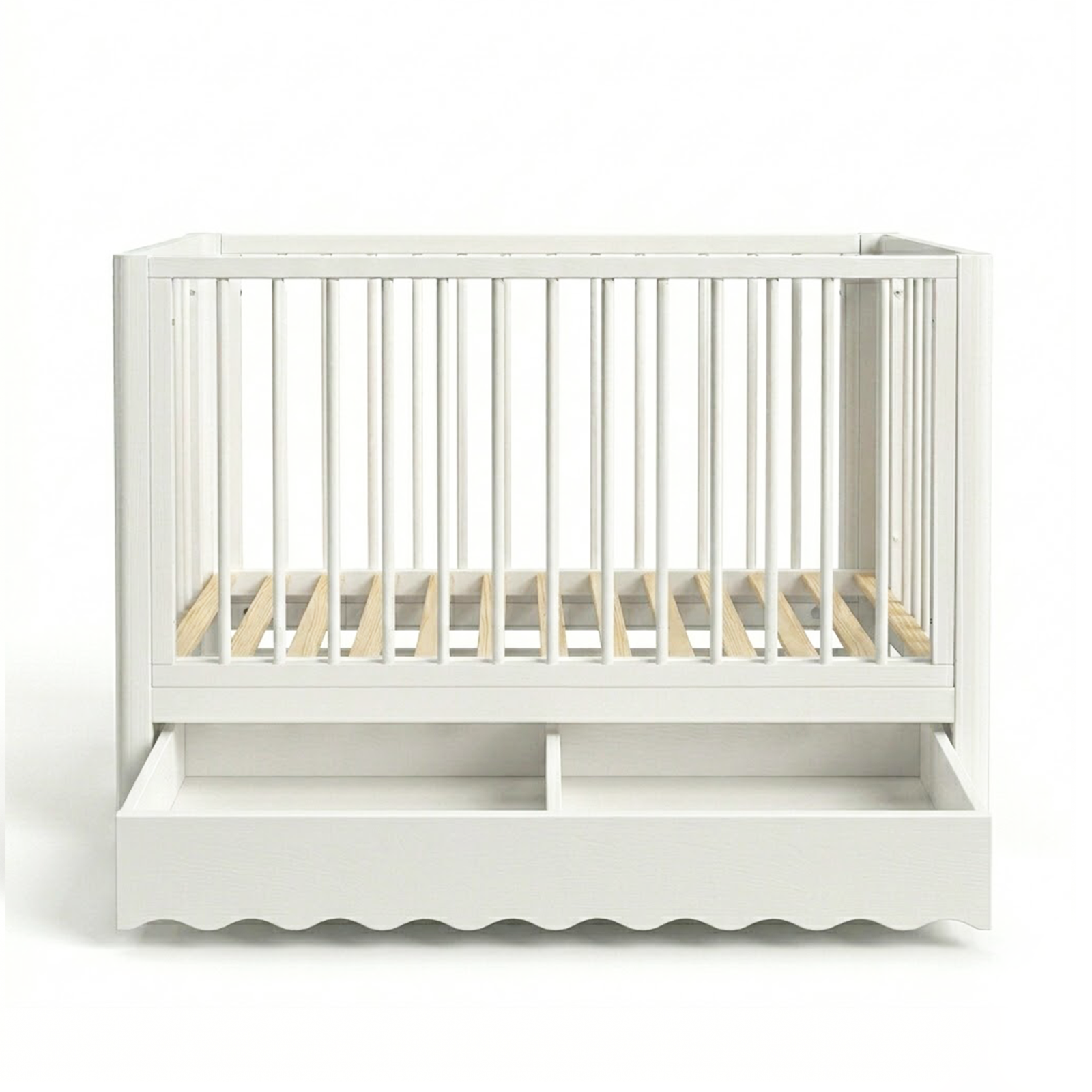 White baby crib on white background showing scalloped bottom edge and drawer