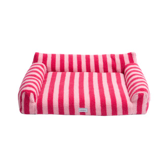 Pink and light pink striped plush pet bed on a white background, showing the entire product with raised sides and brand label
