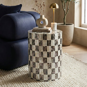 Checkered side table styled in living room next to blue sofa