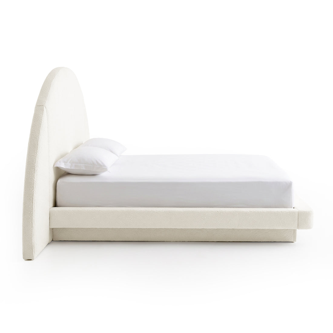 Side view of a modern upholstered bed on a white background