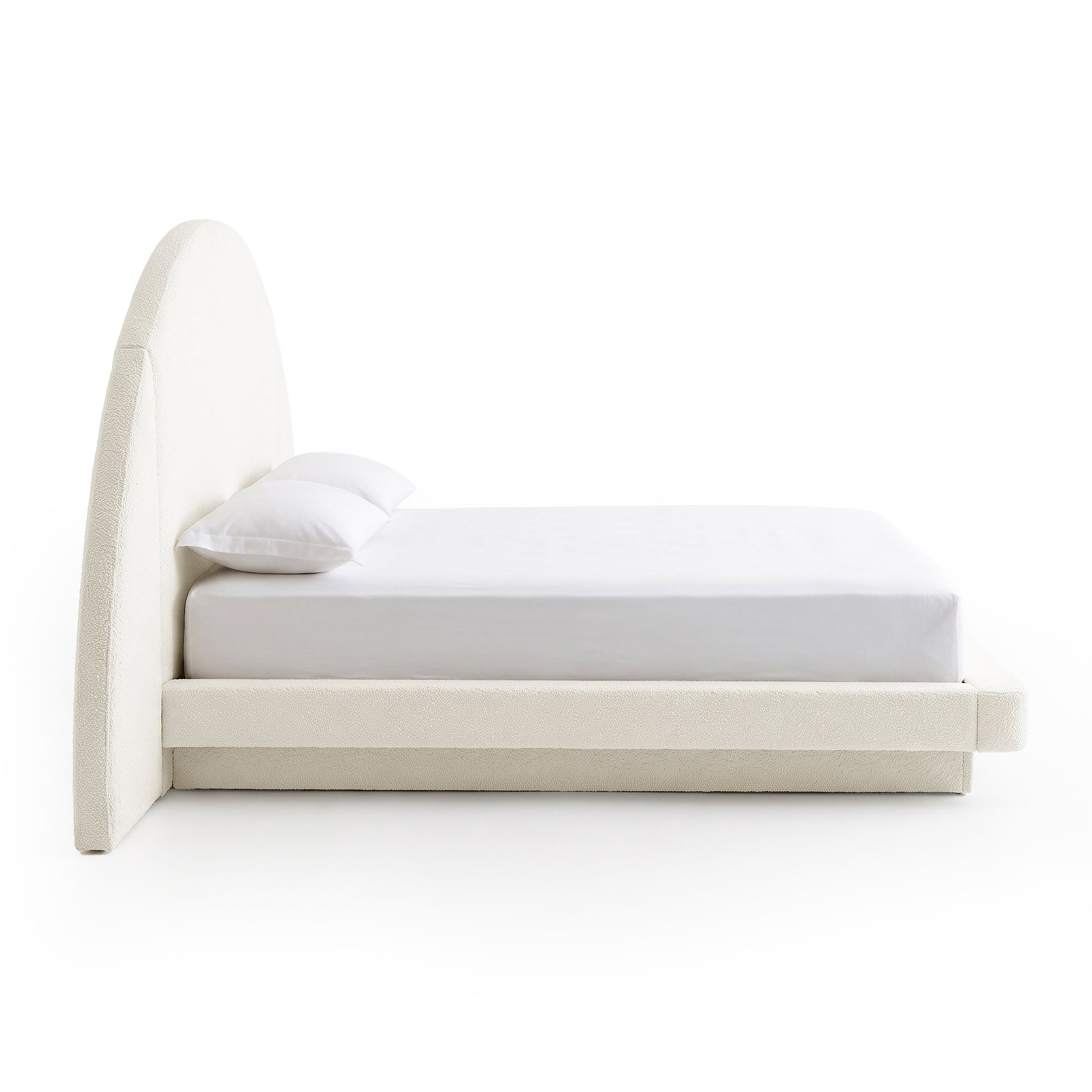Side view of a modern upholstered bed on a white background