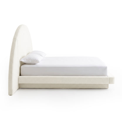 Side view of a modern upholstered bed on a white background