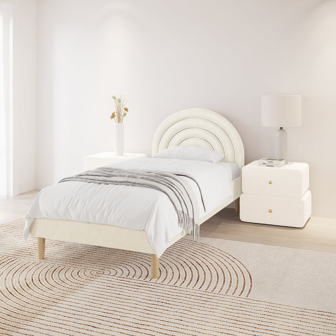 Estilla Velvet Rainbow Bed in Beige features an arched, upholstered headboard. White bedding and a gray throw enhance the minimalist setting, complemented by bedside drawers and decor.