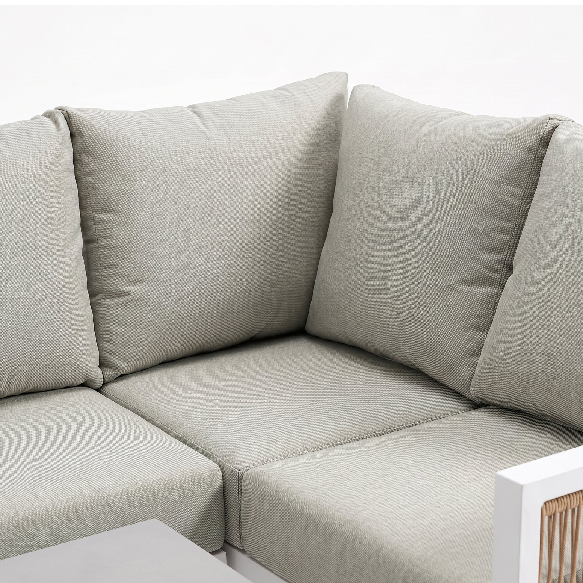 Corner section of an outdoor sectional sofa with light cushions on a white background