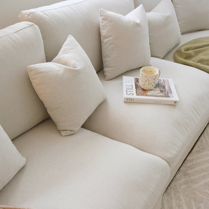 Off-white sectional sofa with pillows and decor in a home interior