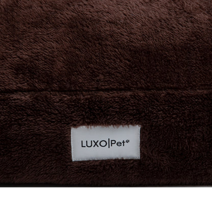 Close-up of plush brown fabric seam and Luxo|Pet label on white background