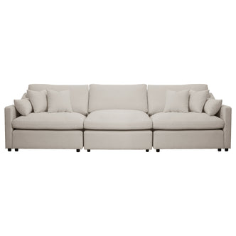 Beige three-seat sofa with five throw pillows on a white background