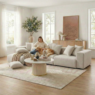 Beige sectional sofa in sunny living room with person and dog