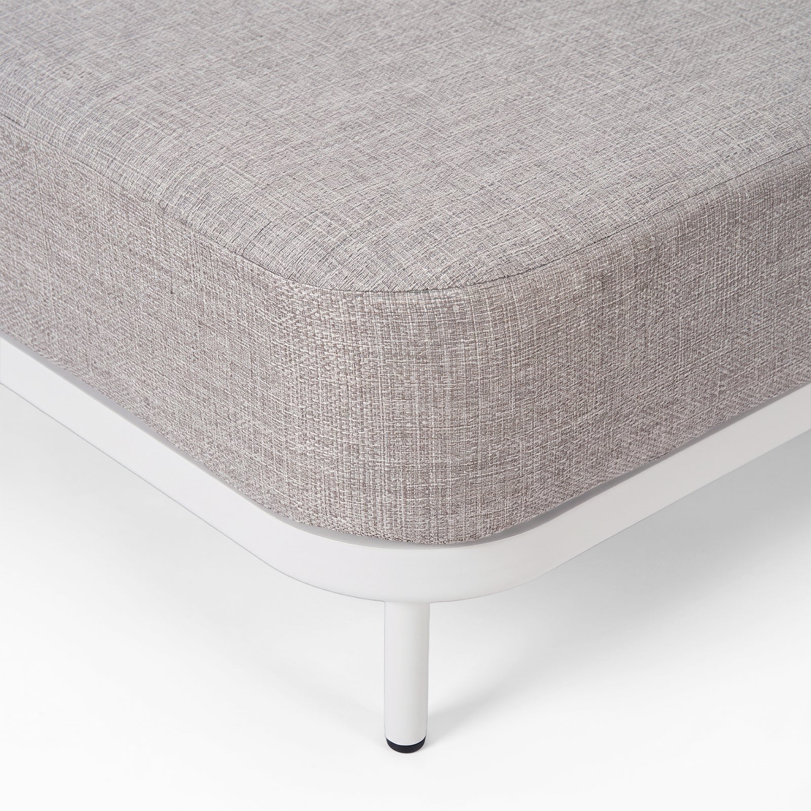 Close-up of the corner and leg of a modern upholstered furniture piece on a white background.