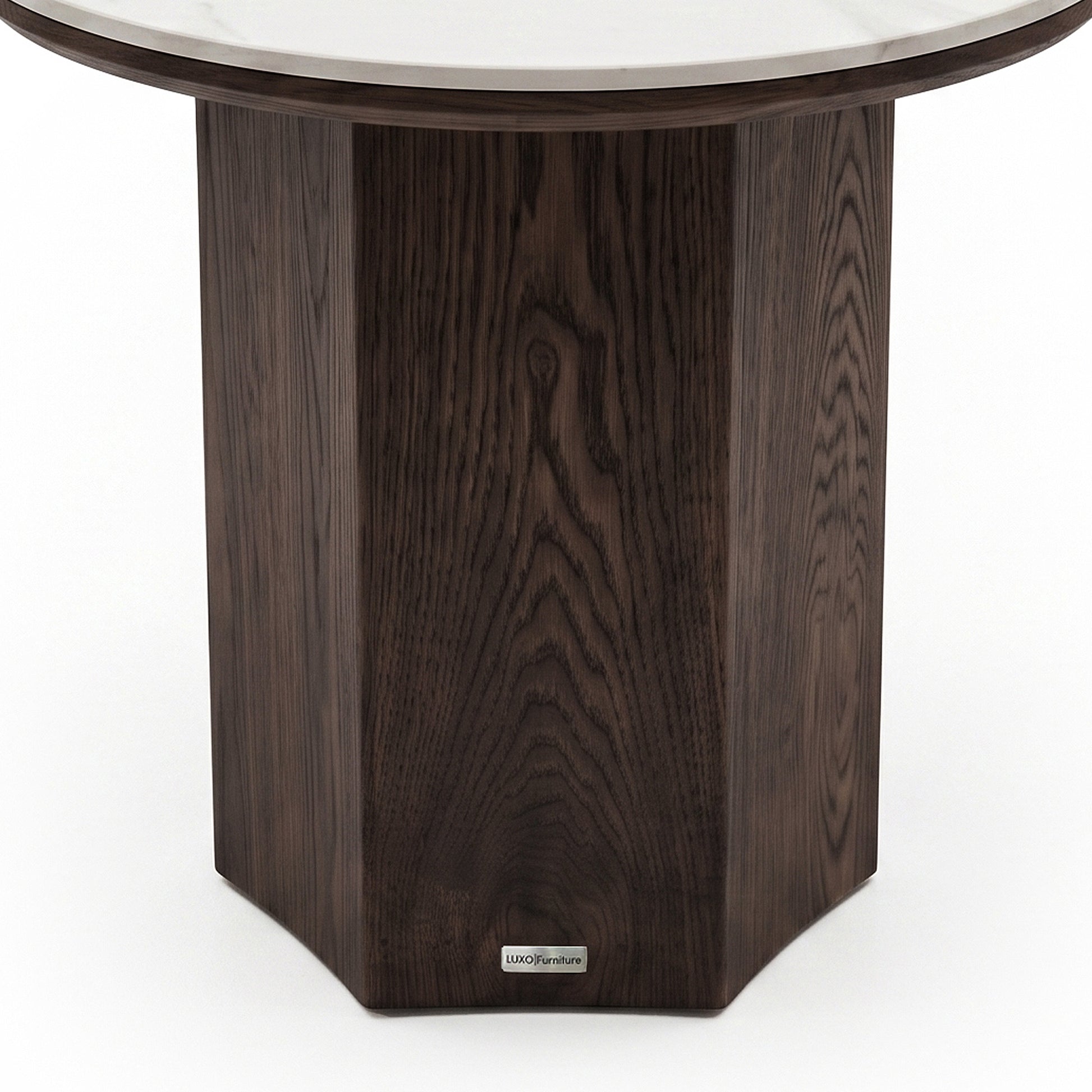 Partial close-up of a round table base with dark wood finish on a white background