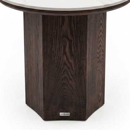 Partial close-up of a round table base with dark wood finish on a white background