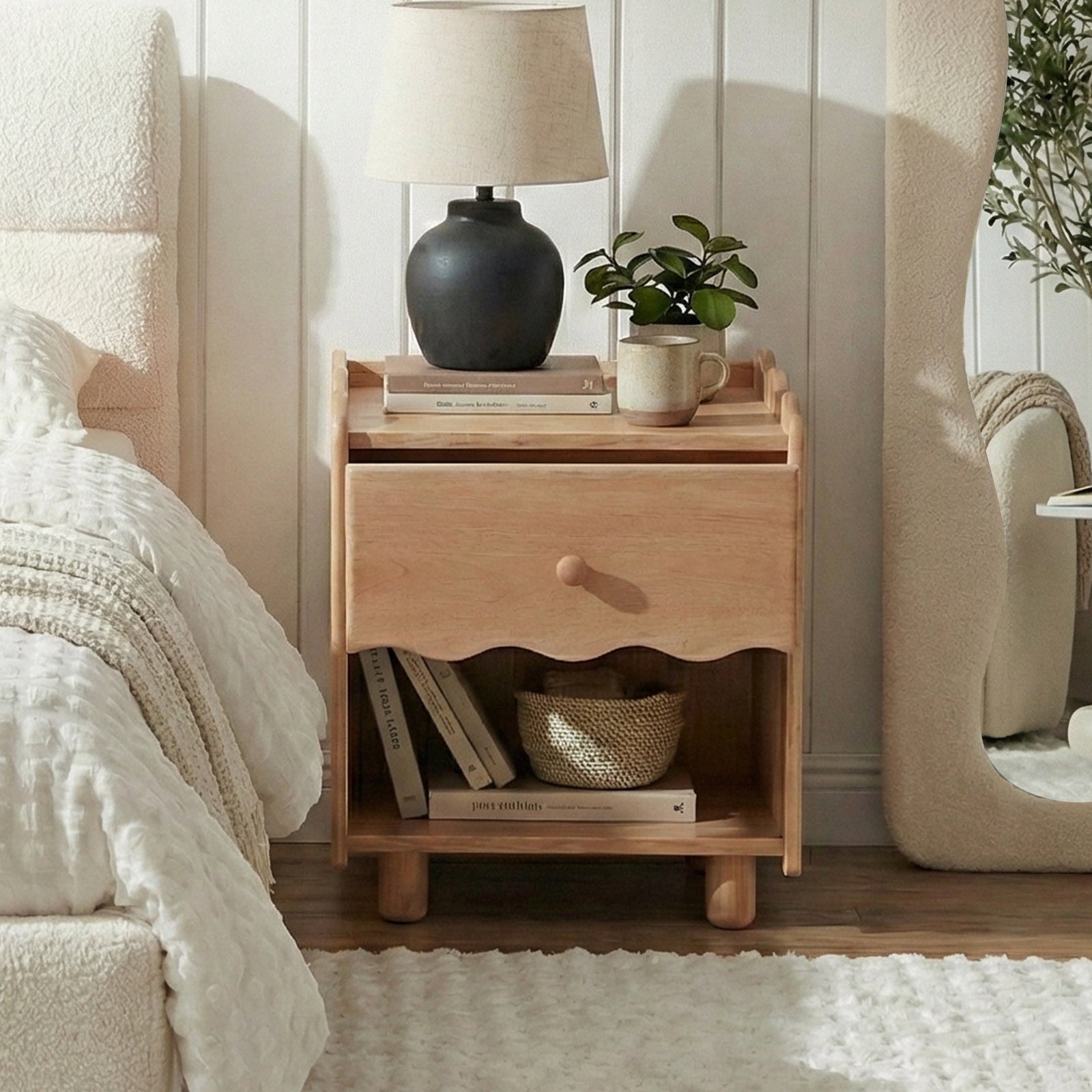 Wooden nightstand styled in a modern bedroom with lamp and mirror