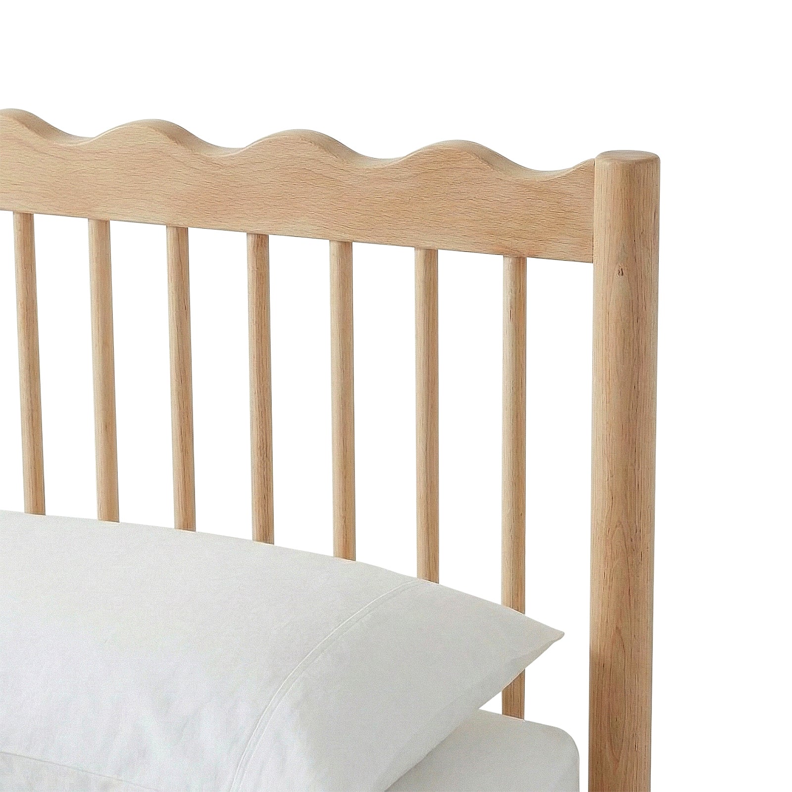 Close-up of wooden headboard with wavy top edge and vertical slats