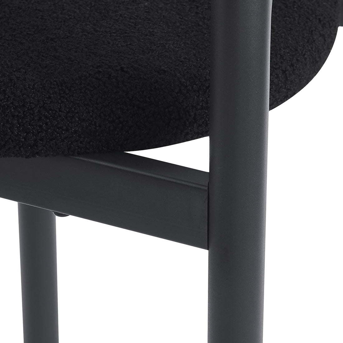 Close-up of black upholstered seat and metal legs on a white background