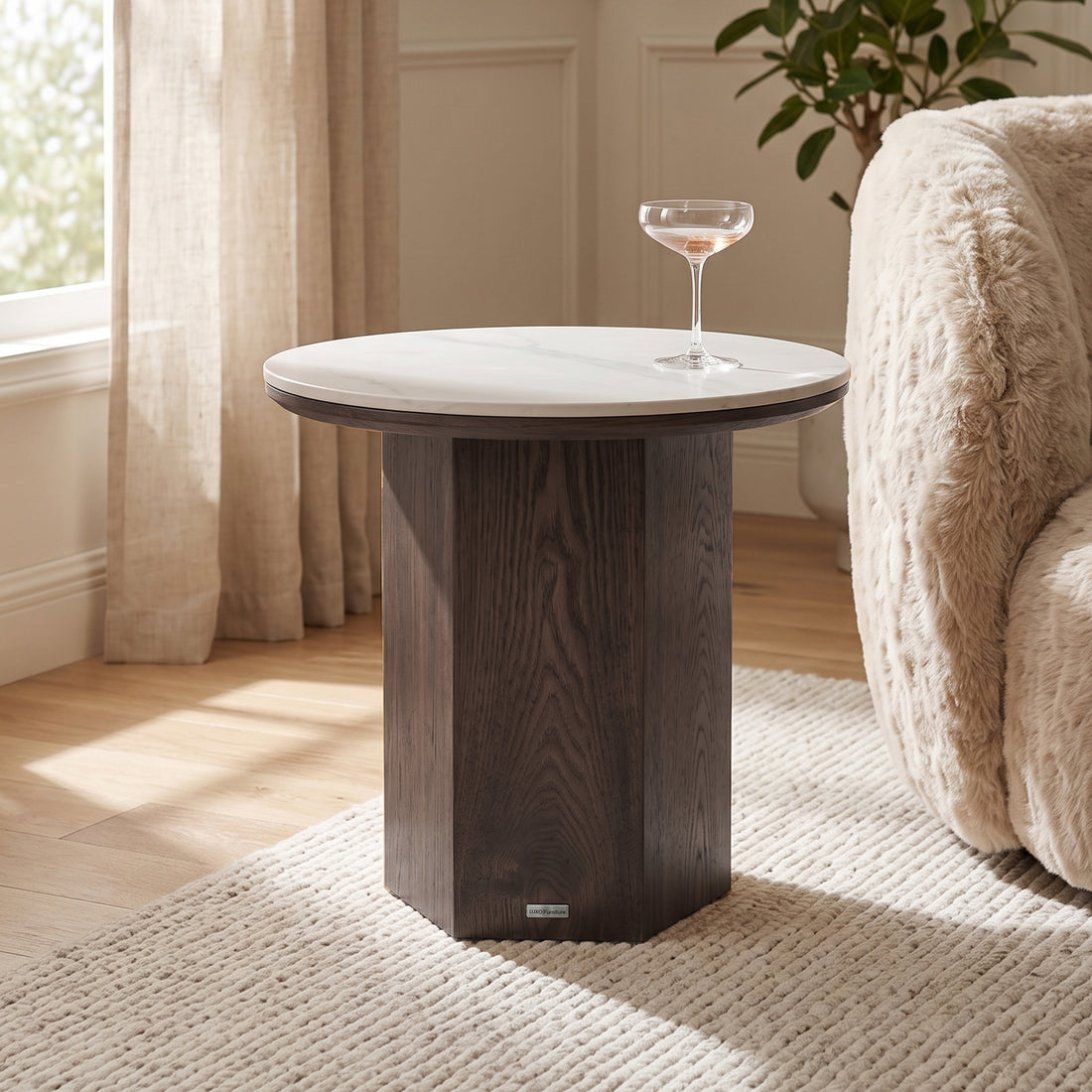 Round side table styled in a living room next to an armchair and rug