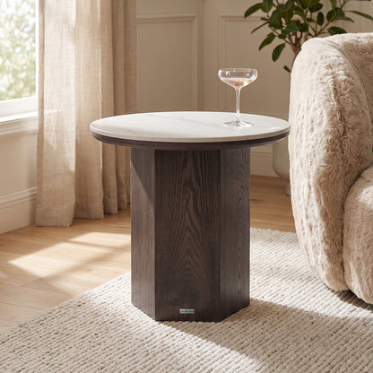 Round side table styled in a living room next to an armchair and rug