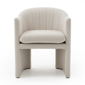 Liora Bouclé Curved Accent Armchair in Beige features a cream bouclé upholstery, curved channel-stitched back, low arms, thick removable cushion, and panel-style legs with arched opening underneath.