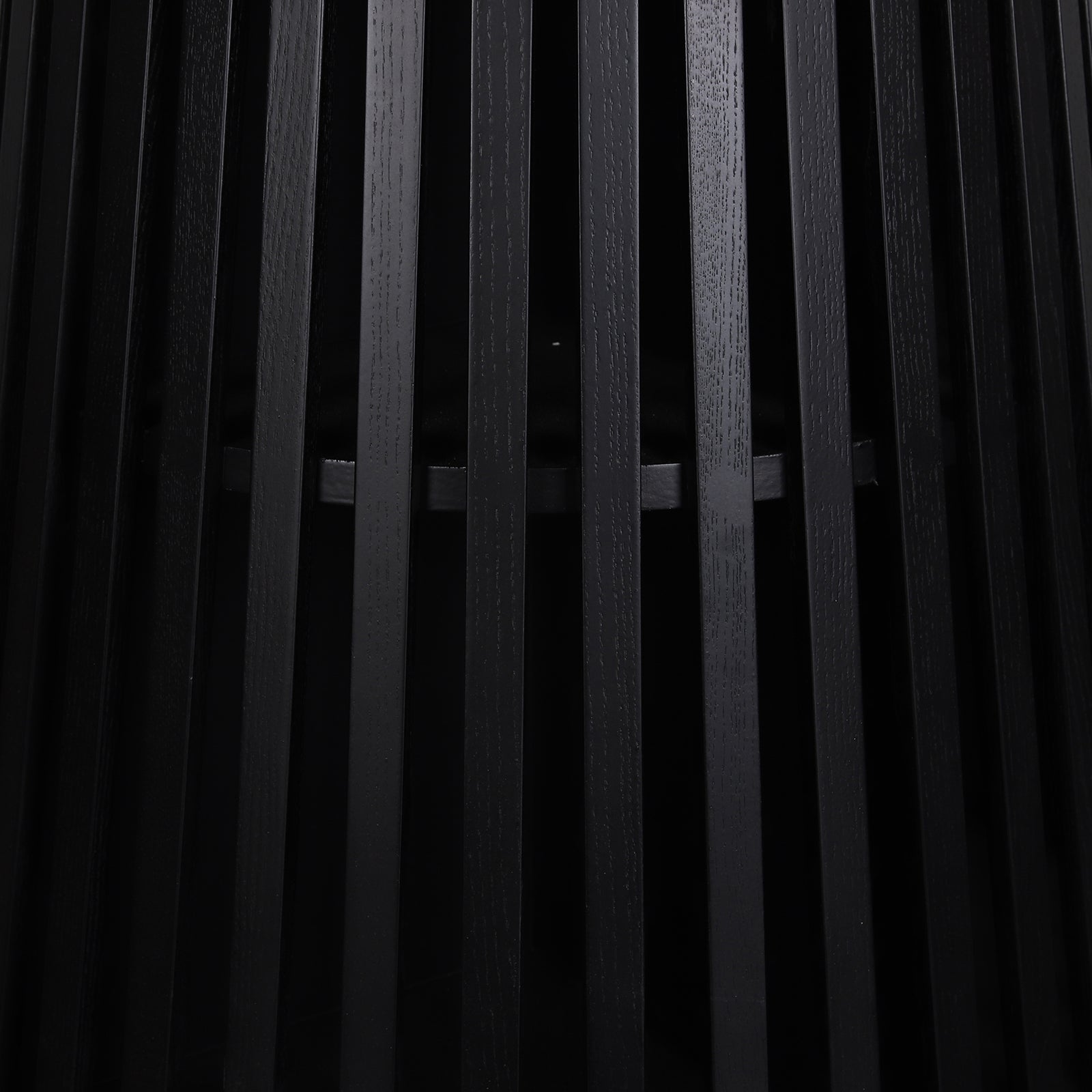 Close-up of the Riri 120cm Round Fluted Wood Dining Table in Black, featuring vertical black wooden slats forming a sleek, textured cylindrical base, highlighting its modern, sculptural design.