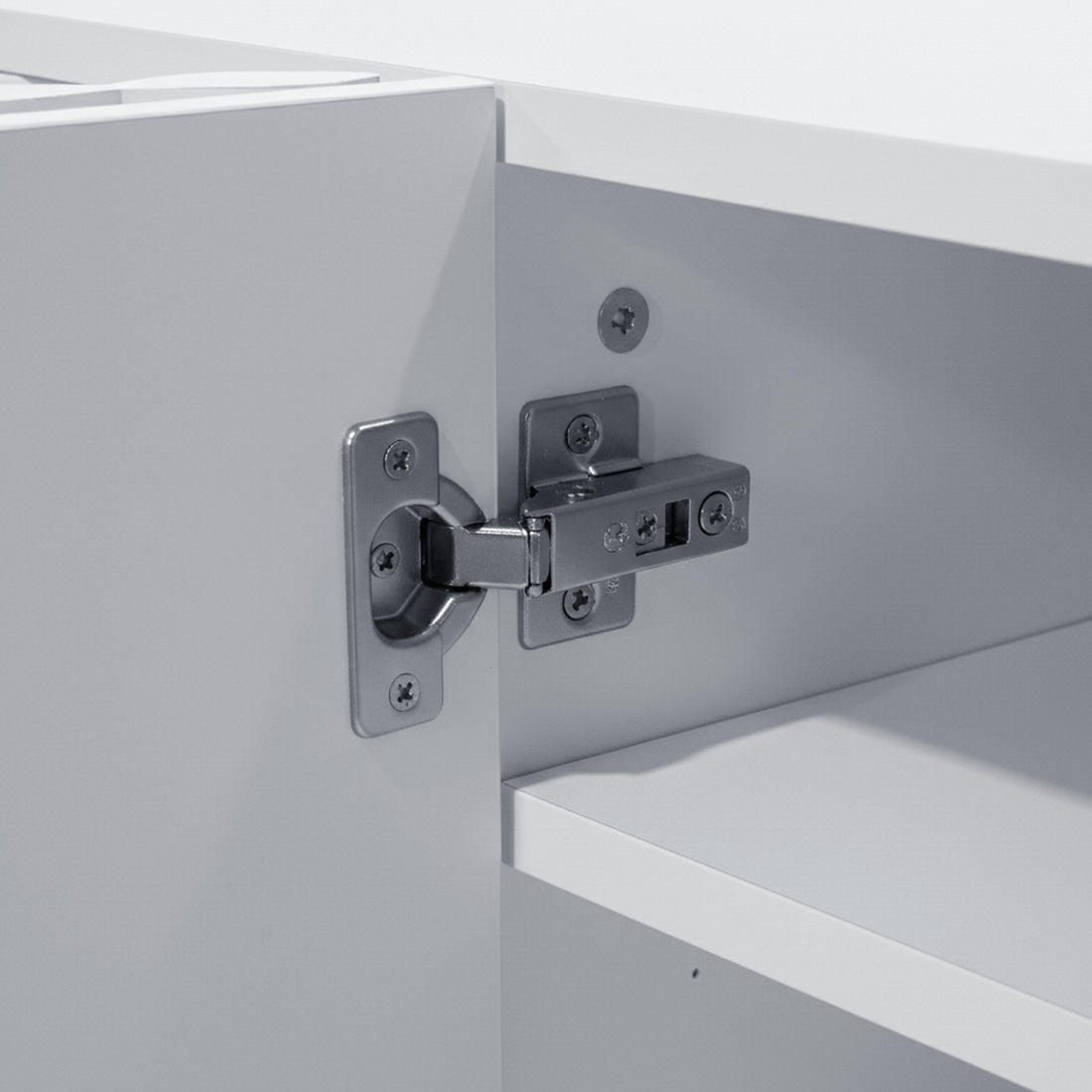 Detail shot of metallic cabinet hinge on white cabinet frame