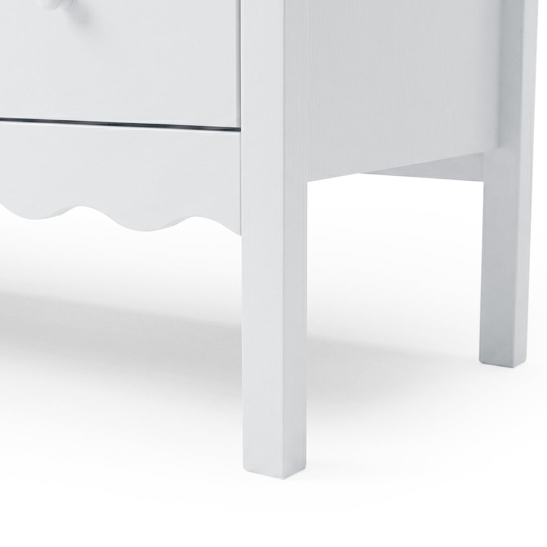 Close-up of lower portion and legs of white dresser on white background