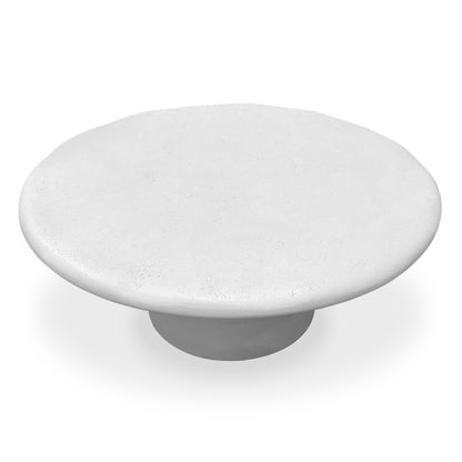 White circular coffee table with flared base on white background