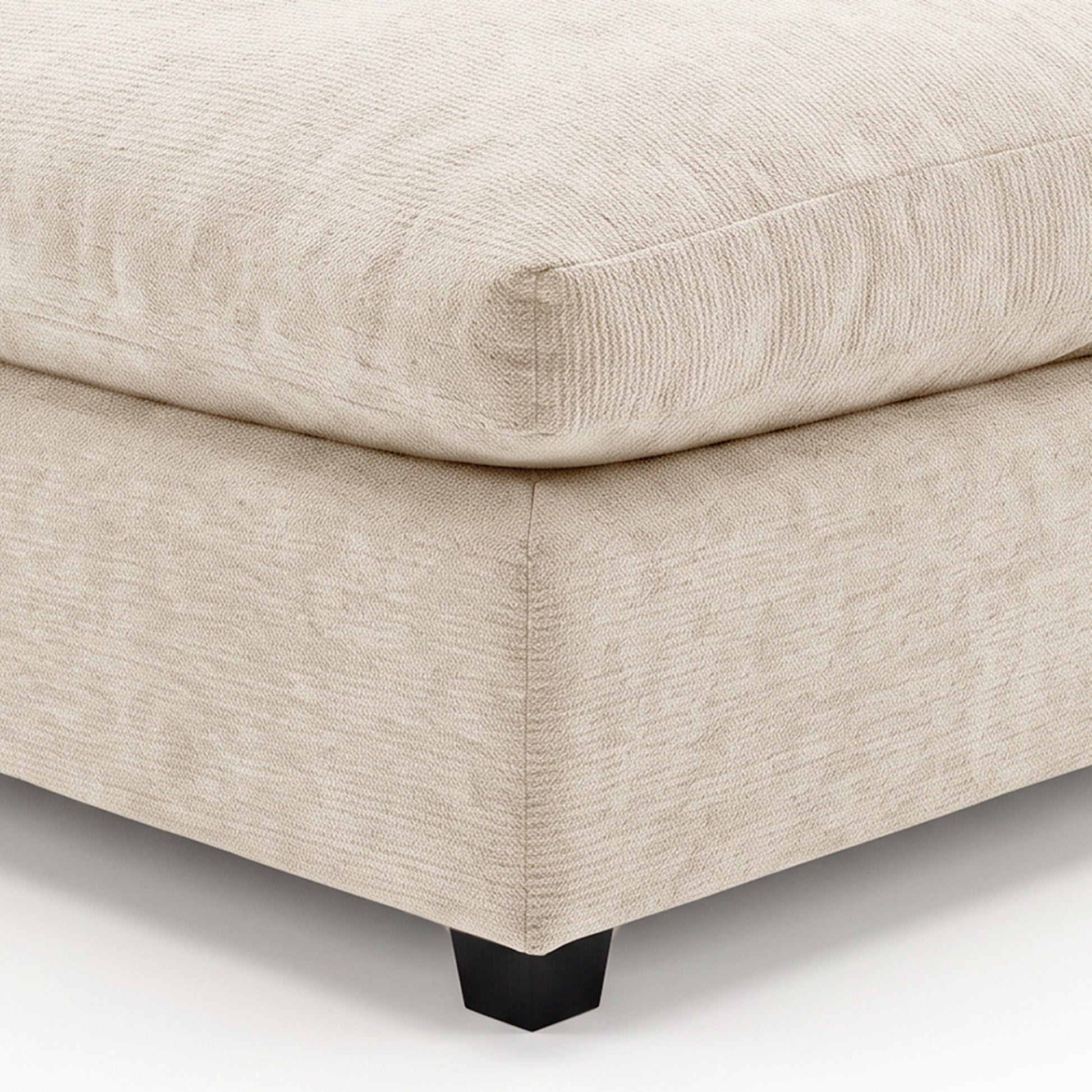 Close-up of beige upholstered furniture corner with visible stitching
