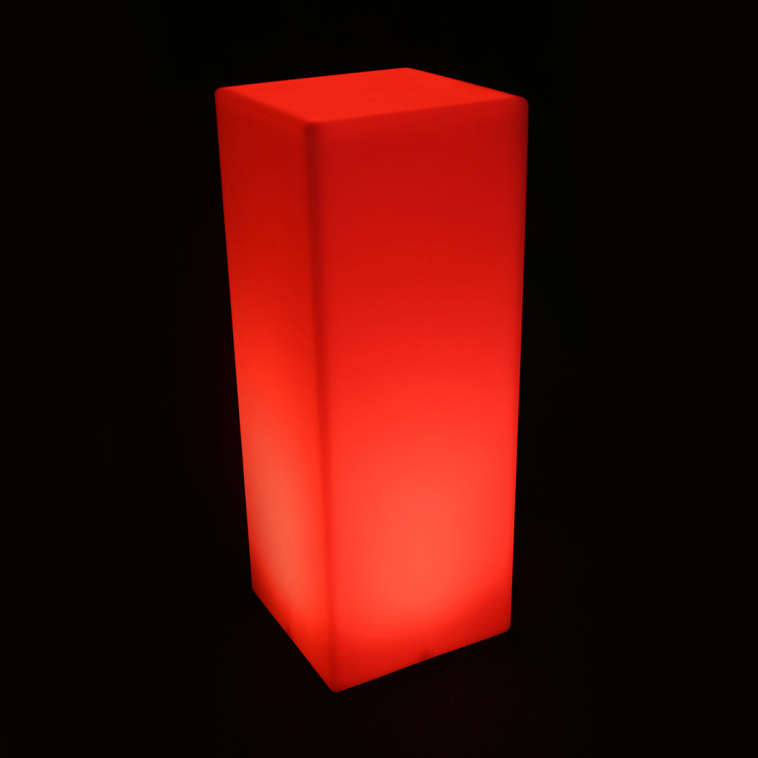Colour Changing LED Column Light Indoor & Outdoor, glowing bright red, stands tall, illuminating its matte surface in a dark setting. Ideal for creating ambience with its versatile LED features.