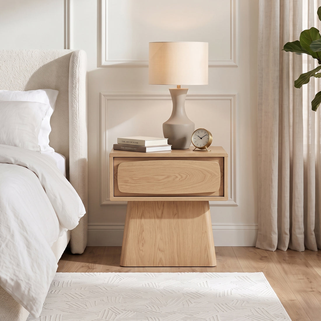 Wooden nightstand styled beside a bed in a bedroom