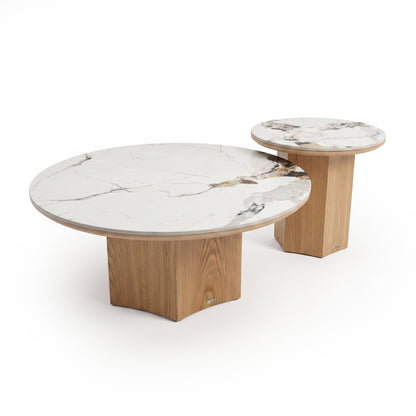 Two round nested tables with white marble tops and light wood bases on a white background.