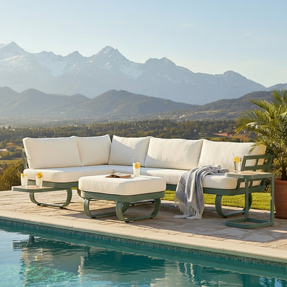 Paloma Modular Outdoor Lounge Set in Olive Green features an L-shaped sofa with white cushions, a cushioned ottoman, and side tables with drinks, set beside a serene pool.