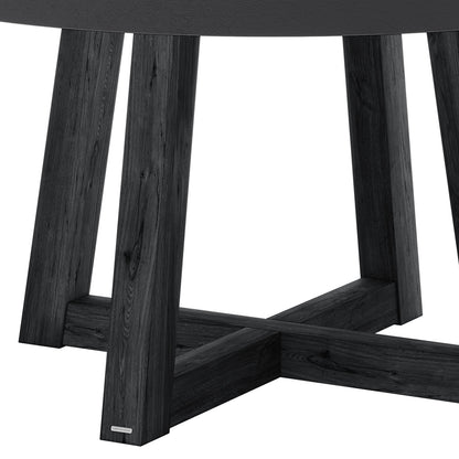 Magnus Hardwood and Concrete Outdoor Dining Table features a dark-stained acacia wood base with splayed legs and X-shaped stretcher, visible under a glimpse of the tabletop edge.