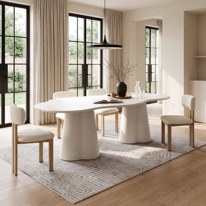 Modern dining table with matching chairs staged in a bright dining room