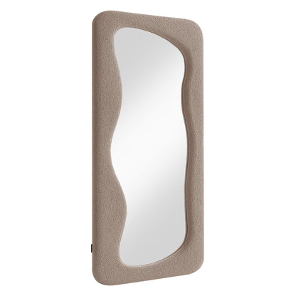 Sabrina 180cm Curved Full Length Mirror features a plush, taupe-colored frame with a wavy reflective surface, blending a modern, sculptural design with cozy boucle texture for stylish interiors.